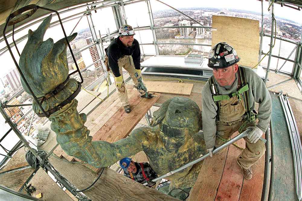 In April 2001, steel workers Ken Olsen (bottom), Doug Jones, (centre), and Jeff Trudel prepare scaffolding around the Golden Boy atop the Manitoba Legislature.