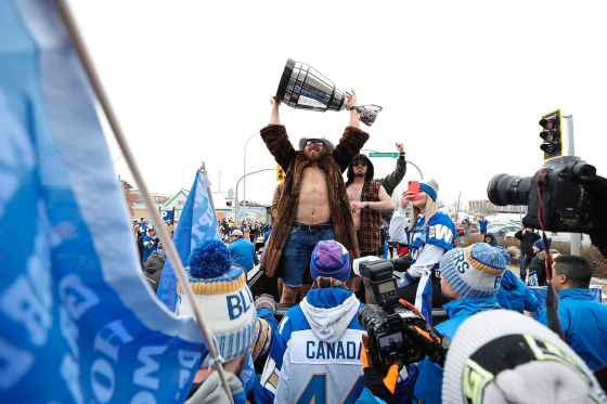 RUTH BONNEVILLE / WINNIPEG FREE PRESS Chris Streveler shows off the Grey Cup during a downtown parade in November to celebreate the championship win by the Winnipeg Blue Bombers.