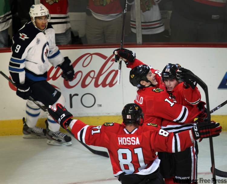 Chicago Blackhawks' Patrick Kane, right, is congratulated by teammates Marian Hossa and Daniel Carcillo for his first-period goal as Winnipeg Jets' Evander Kane looks on. (Joe Bryksa / Winnipeg Free Press)