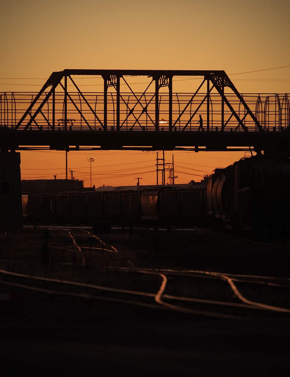 A pedestrian crosses the Arlington bridge at sunset in 2011. (John Woods / Winnipeg Free Press files)