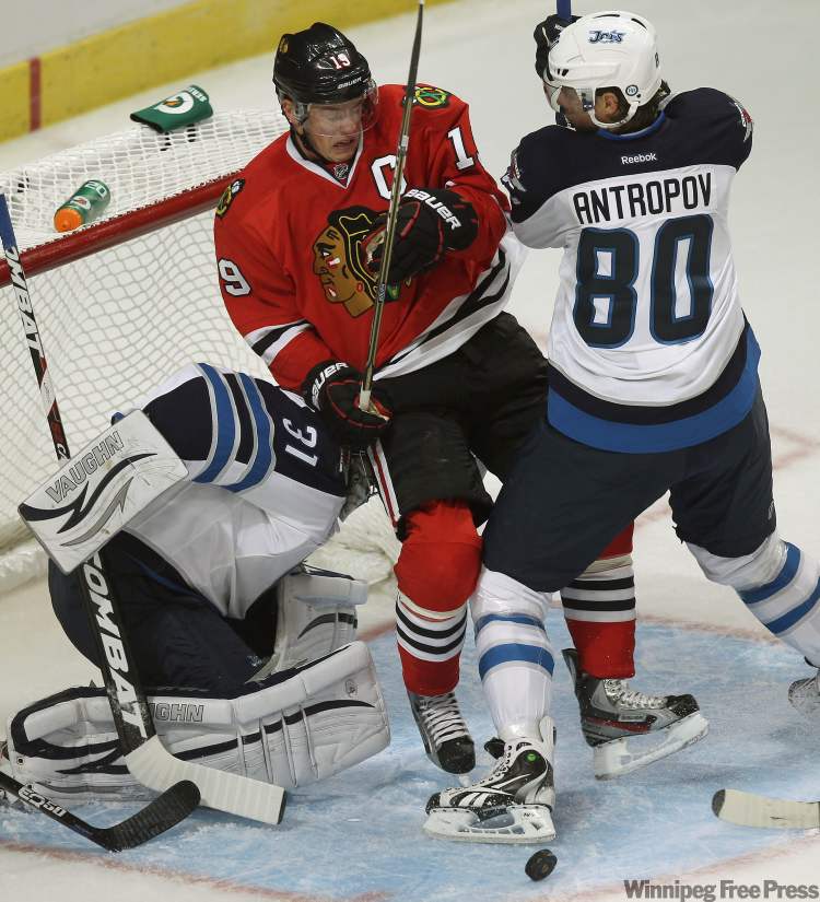 Chicago Blackhawks' Jonathan Toews, centre, gets pushed into Winnipeg Jets goaltender Ondrej Pavelec by Jets' Nik Antropov during first-period action. (Joe Bryksa / Winnipeg Free Press)