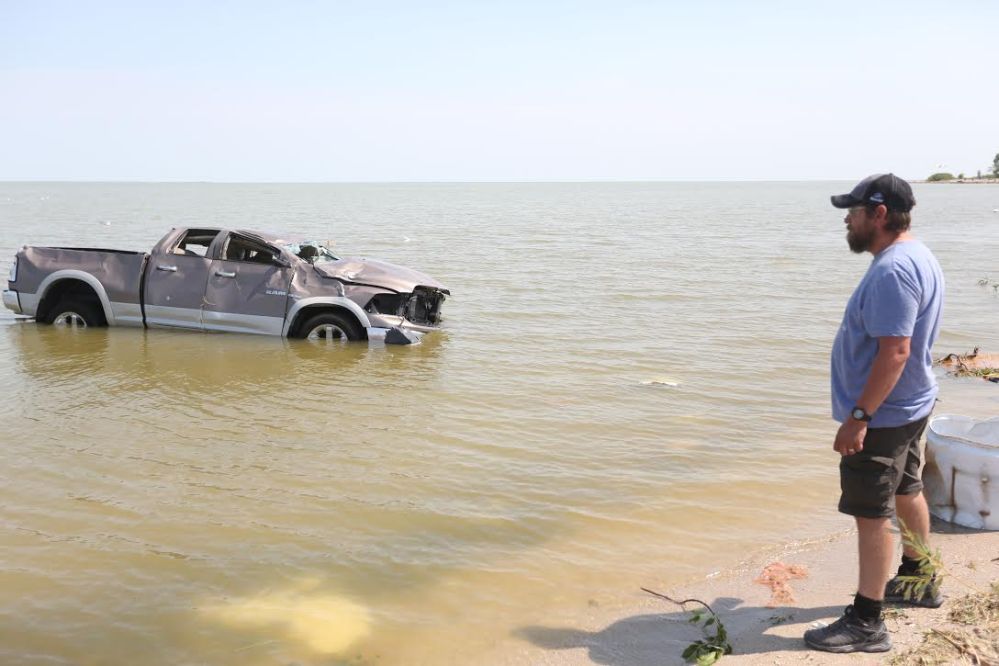 Shawn Gurke, a resident of Alonsa, watched a truck floating in Lake Manitoba after a tornado hit on Friday. (Melissa Verge / The Brandon Sun)