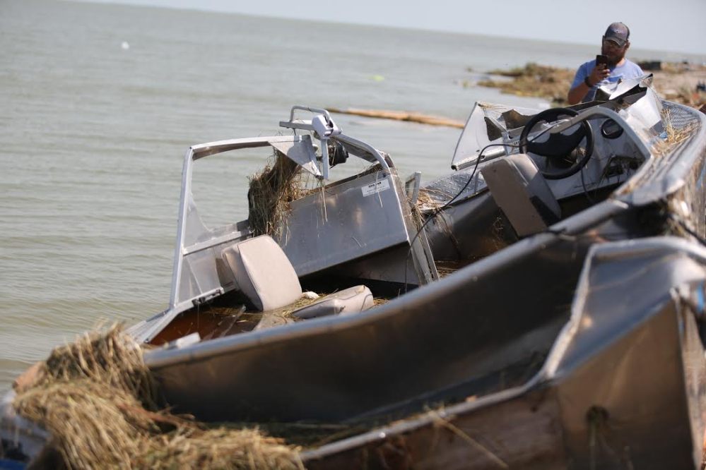 Alonsa-area resident Shawn Burke takes a photo of his boat that was badly damaged after a tornado hit Margaret Bruce Beach on Friday. (Melissa Verge / The Brandon Sun)