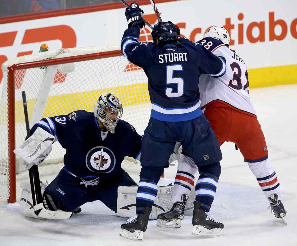 Trevor Hagan / Winnipeg Free Press
Winnipeg Jets' goaltender Ondrej Pavelec (31) stops a bouncing puck with Mark Stuart (5) and Columbus Blue Jackets' Boone Jenner (38) in front of the net during the first period at Winnipeg's MTS Centre Saturday.