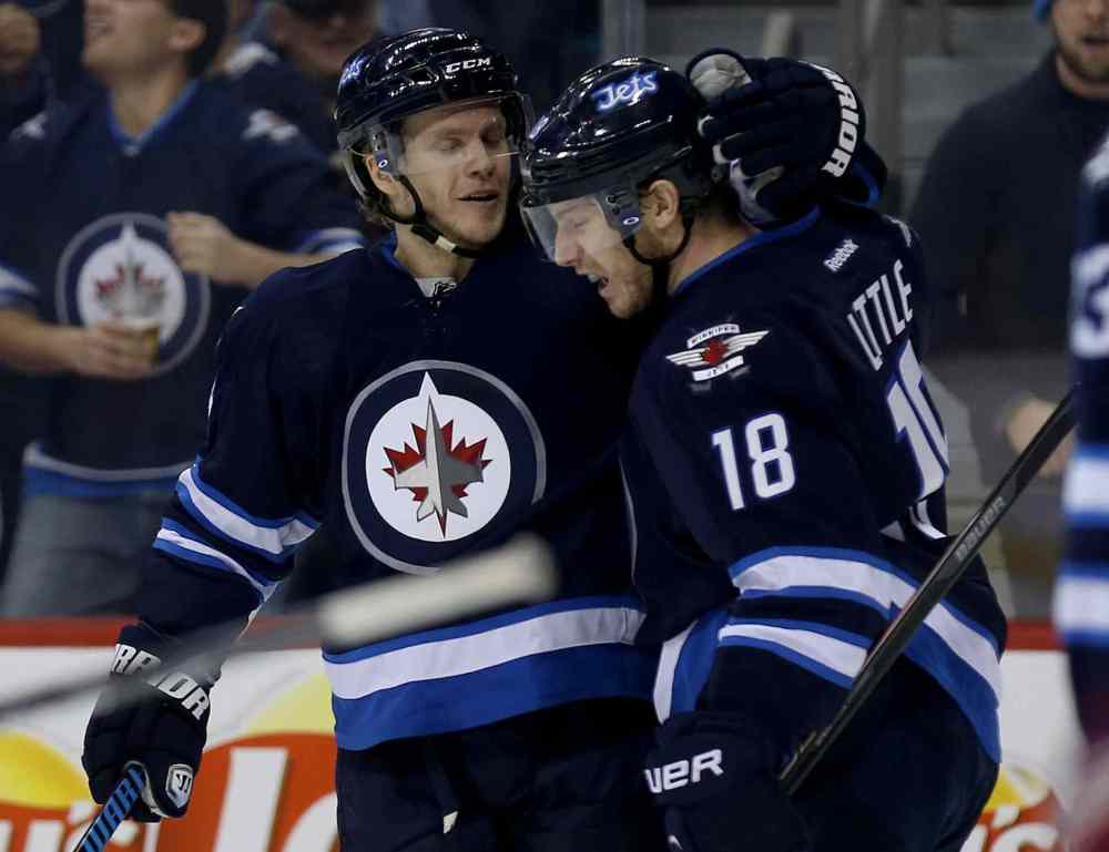 Trevor Hagan / Winnipeg Free Press
Winnipeg Jets' Tobias Enstrom (39) and Bryan Little (18) celebrate after Enstrom scored in the second period Saturday at MTS Centre.