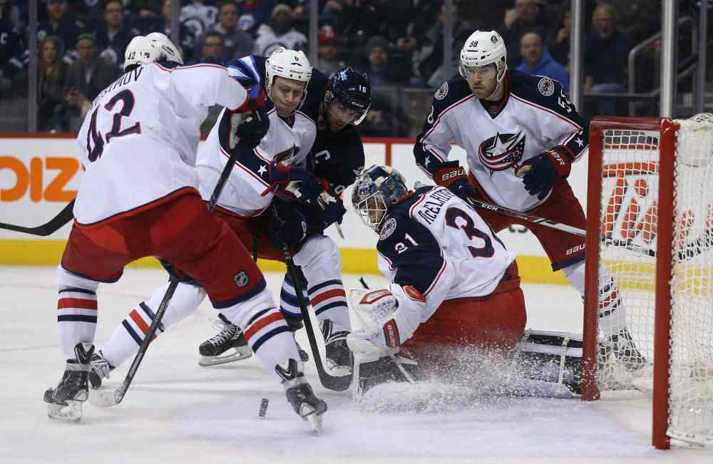 Trevor Hagan / Winnipeg Free Press
Winnipeg Jets' Andrew Ladd (16) battles with Columbus Blue Jackets' Artem Anisimov (42), Nikita Nikitin (6) goaltender Curtis McElhinney (31), and David Savard (58) for a loose puck during the second period Saturday.