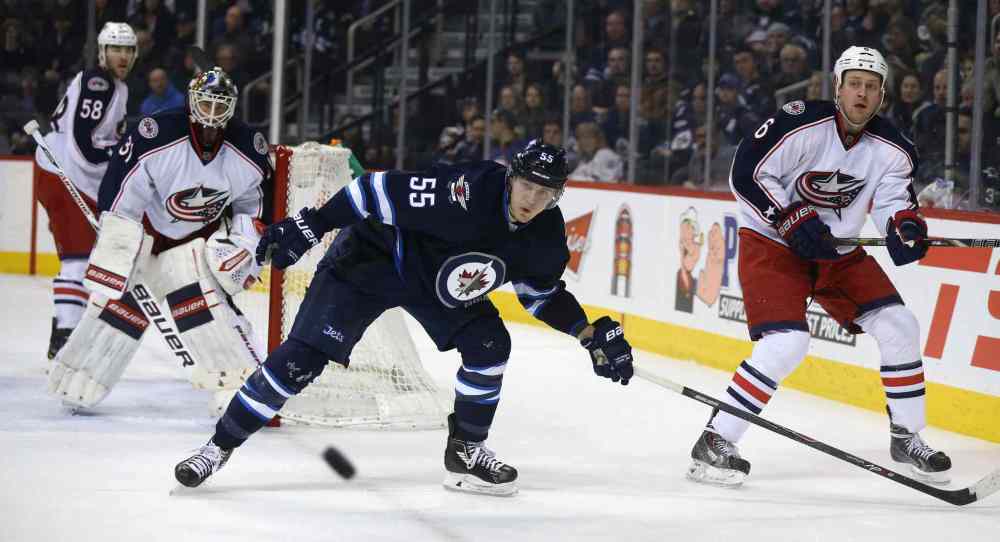 Trevor Hagan / Winnipeg Free Press
Winnipeg Jets' Mark Scheifele (55) and Columbus Blue Jackets' Nikita Nikitin (6) watch a puck head to the corner in the second period Saturday.