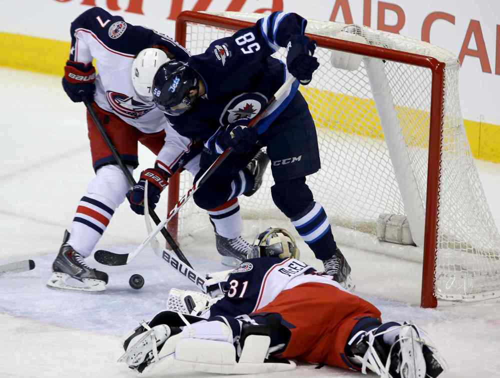 Trevor Hagan / Winnipeg Free Press
Columbus Blue Jackets' Jack Johnson (7) battles with Winnipeg Jets' Eric O'Dell (58) in the crease behind goaltender Curtis McElhinney (31). Then, O'Dell manages to put the puck in the net for his first career NHL goal during first period Saturday.