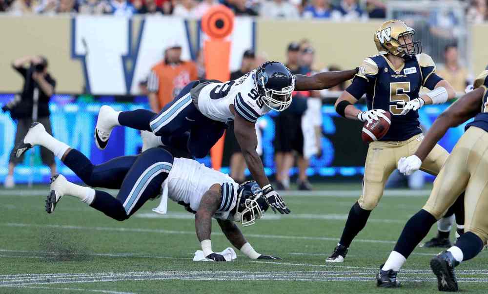 TREVOR HAGAN / THE CANADIAN PRESS
Bombers quarterback Drew Willy eludes the rush from Argos defenders Greg Romeus (99) and Thaddeus Gibson.