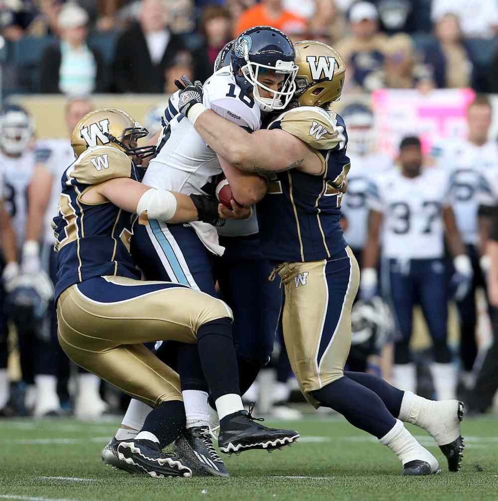 TREVOR HAGAN / THE CANADIAN PRESS
Argos quarterback Mitchell Gale gets sacked by Bombers defenders Greg Peach, right, and Zach Anderson during the first half.