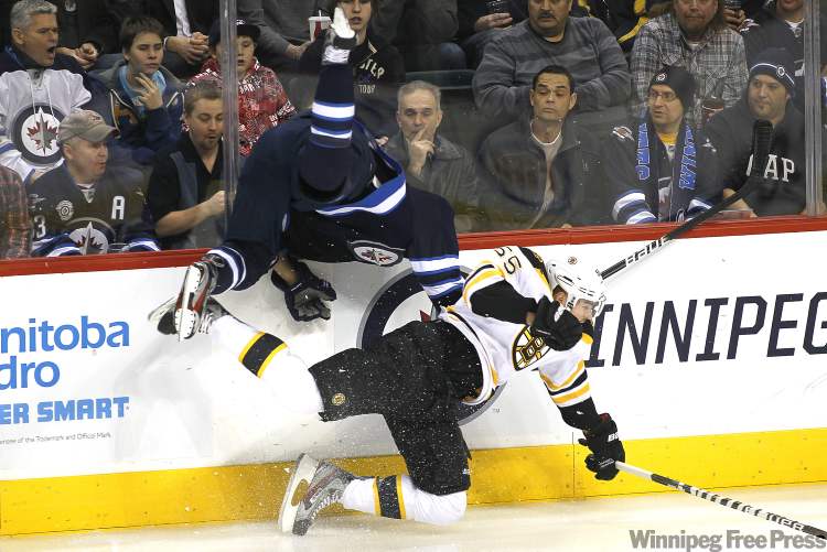 John Woods / WINNIPEG FREE PRESS
Winnipeg Jets' forward Evander Kane (9) gets upended by Boston Bruins' defenceman Johnny Boychuk (55) during first-period NHL action in Winnipeg on Tuesday.