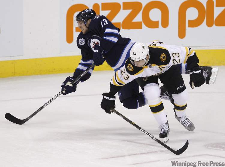 Trevor Hagan / The Canadian Press
Winnipeg Jets' Kyle Wellwood (13) and Boston Bruins' Chris Kelly collide during first-period NHL action in Winnipeg Tuesday.
