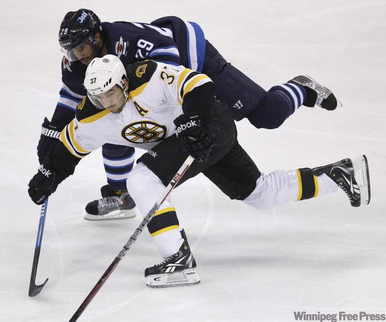 Trevor Hagan / The Canadian Press
Winnipeg Jets' Johnny Oduya (29) battles with Boston Bruins' Patrice Bergeron during second-period NHL action in Winnipeg Tuesday.