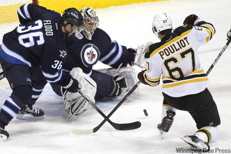 John Woods / Winnipeg Free Press
Winnipeg Jets' goaltender Ondrej Pavelec (31) and defenceman Mark Flood (36) fight for the rebound with Boston Bruins' forward Benoit Pouliot (67) during first-period NHL action in Winnipeg on Tuesday.