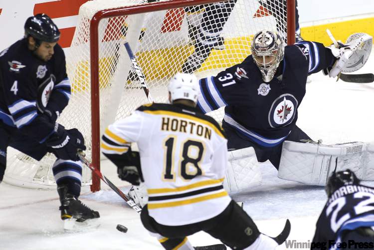 John Woods / Winnipeg Free Press
Winnipeg Jets' goaltender Ondrej Pavelec (31) and defenceman Zach Bogosian (4) fight for the rebound with Boston Bruins' forward Nathan Horton (18) during first period NHL action in Winnipeg on Tuesday.