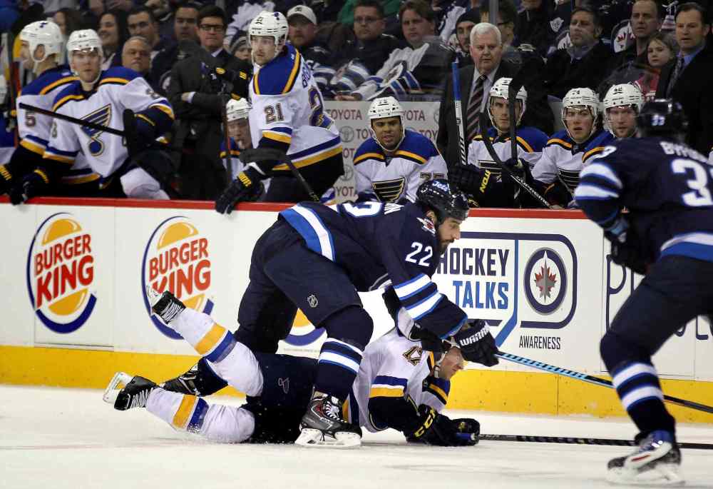 Phil Hossack / Winnipeg Free Press
Winnipeg Jets' Chris THorburn takes down St Louis Blues' Jaden Schwartz in front of the Blues bench in the first period of Thursday's game at the MTS Centre.