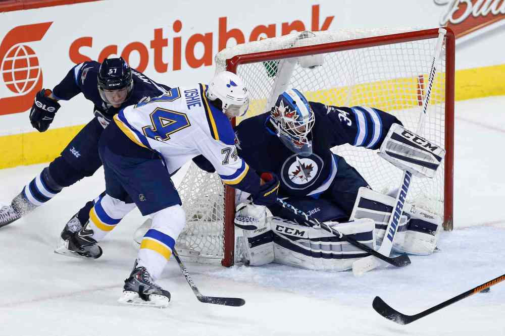 John Woods / The Canadian Press
St. Louis Blues T.J. Oshie (74) fans on the wrap around on Winnipeg Jets goaltender Michael Hutchinson (34) as Tyler Myers (57) defends during second period.