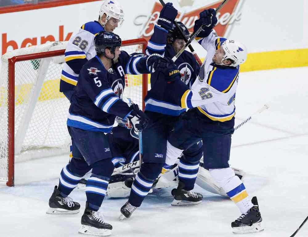 John Woods / The Canadian Press
Winnipeg Jets' Jacob Trouba (8) and Mark Stuart (5) attempt to clear St. Louis Blues David Backes (42) as Paul Stastny (26) looks for the rebound from Jets goaltender Michael Hutchinson (34) during second period.