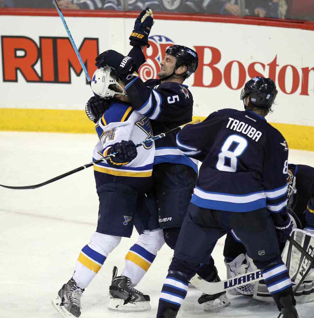 Phil Hossack / Winnipeg Free Press
Winnipeg Jets Mark Stuart and St. Louis Blues T.J. Oshie tangle in front of the Jets' net in overtime at the MTS Centre Thursday.