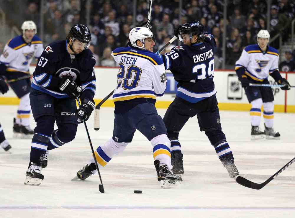 Phil Hossack / Winnipeg Free Press
Winnipeg Jets Michael Frolik (left) and Toby Enstrom take the puck from St. Louis Blues Alexander Steen during the first period.