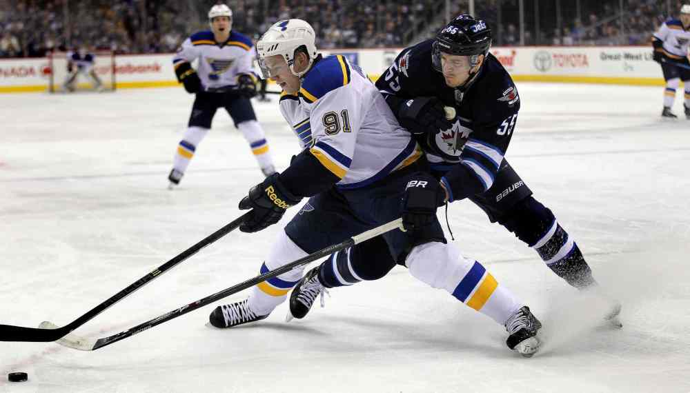 Phil Hossack / Winnipeg Free Press
Winnipeg Jets Mark Scheifele reaches around St. Louis Blues Vladimir Tarasenko in the first period at the MTS Centre Thursday.
