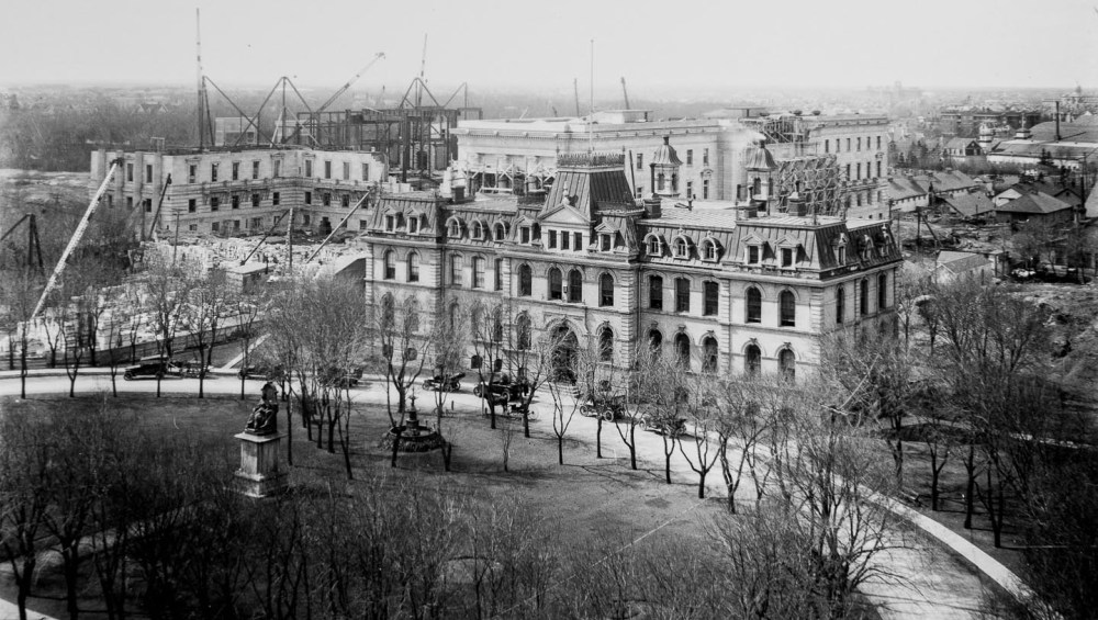 A view of the construction site from St. Stephens Church in May 1917. The city's second legislative building, which was demolished when the current one was completed, is in the foreground. (Archives of Manitoba).