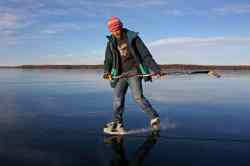 Tim Smith / Brandon Sun
Jesse Matas of Riding Mountain National Park skates on the smooth-as-glass ice covering Clear Lake in the Park on a sunny and warm Monday afternoon. Matas skated across the lake to the townsite of Wasagaming and back again. The lack of snow so far this year has created a rare opportunity for winter enthusiasts to enjoy the clear ice.