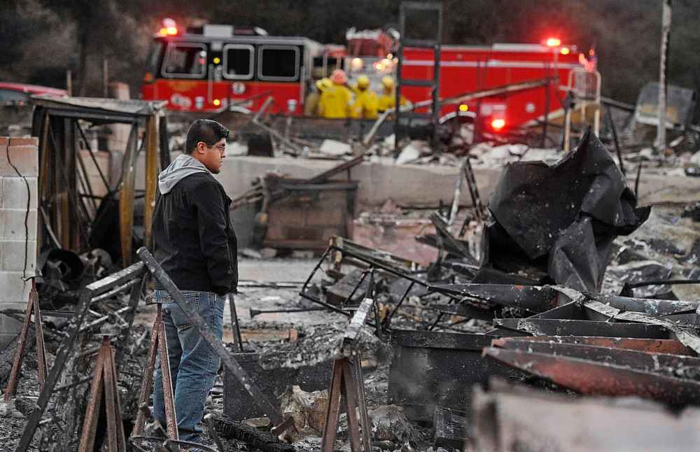Ricky Alvarado looks over the charred remains of his home at the Seminole Springs Mobile Home Park on Sunday in Agoura Hills, Calif. (Chris Pizzello / The Associated Press)