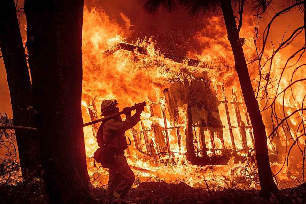 CP
Firefighter Jose Corona sprays water as flames consume a home in Magalia, Calif., on Friday. (Noah Berger / The Associated Press)