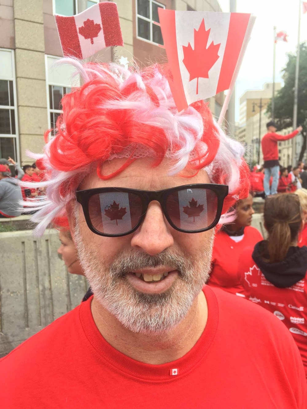 BORIS MINKEVICH / WINNIPEG FREE PRESS
Gil Tetreault gets in the spirit of things at the attempt to create the largest living flag at Portage & Main Saturday morning.