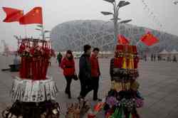 Ng Han Guan / The Associated Press
Tourists pass by memorabilia on sale near the iconic Bird