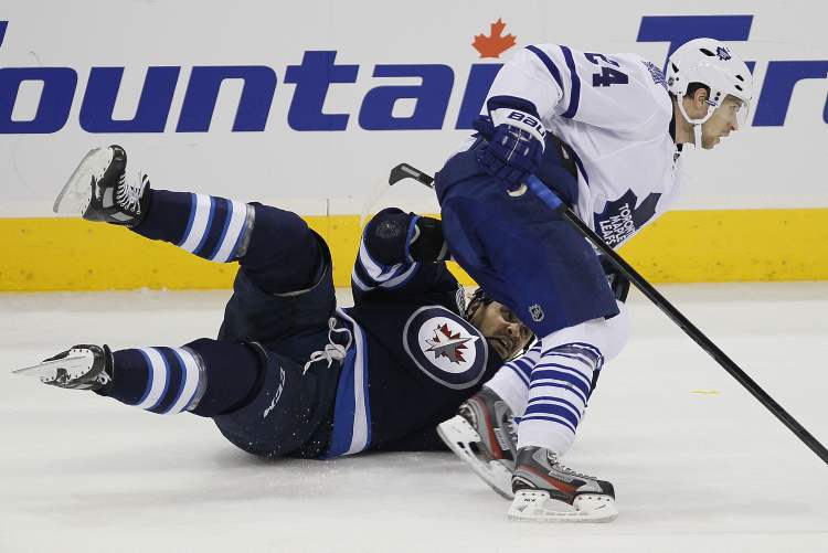 John Woods / Winnipeg Free Press
Winnipeg Jets' Dustin Byfuglien is taken down by Toronto Maple Leafs' John-Michael Liles during third-period NHL action Tuesday at the MTS Centre.