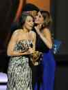 The Associated Press
Tina Fey, right, is embraced by L L Cool J as Tracey Wigfield, left, accepts the award for outstanding writing for a comedy series for their work on 30 Rock at the 65th Primetime Emmy Awards Sunday