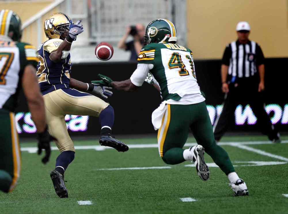 Phil Hossack / Winnipeg Free Press
Winnipeg Blue Bombers' running back Nic Grigsby bobbles a pass into the waiting hands of Edmonton Eskimos' Odell Willis early in the game Thursday. Willis took it and ran to score the Eskimo's opening touch down.
