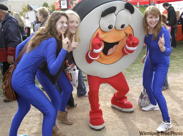 Jets fans, from left, Lorelle Juffs, Meagan Kubanek and Baylie Gigolyk pose with Peter Puckprior at The Forks. (Wayne Glowacki / Winnipeg Free Press)