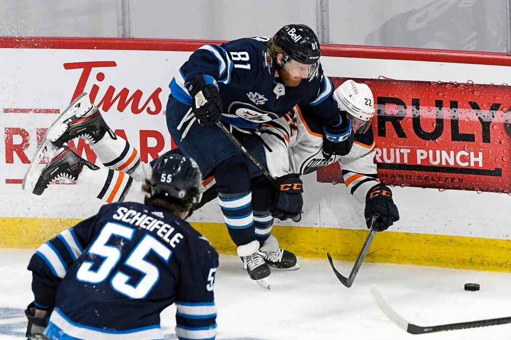 Kyle Connor checks Tyson Barrie during the first overtime period. (Fred Greenslade / The Canadian Press)