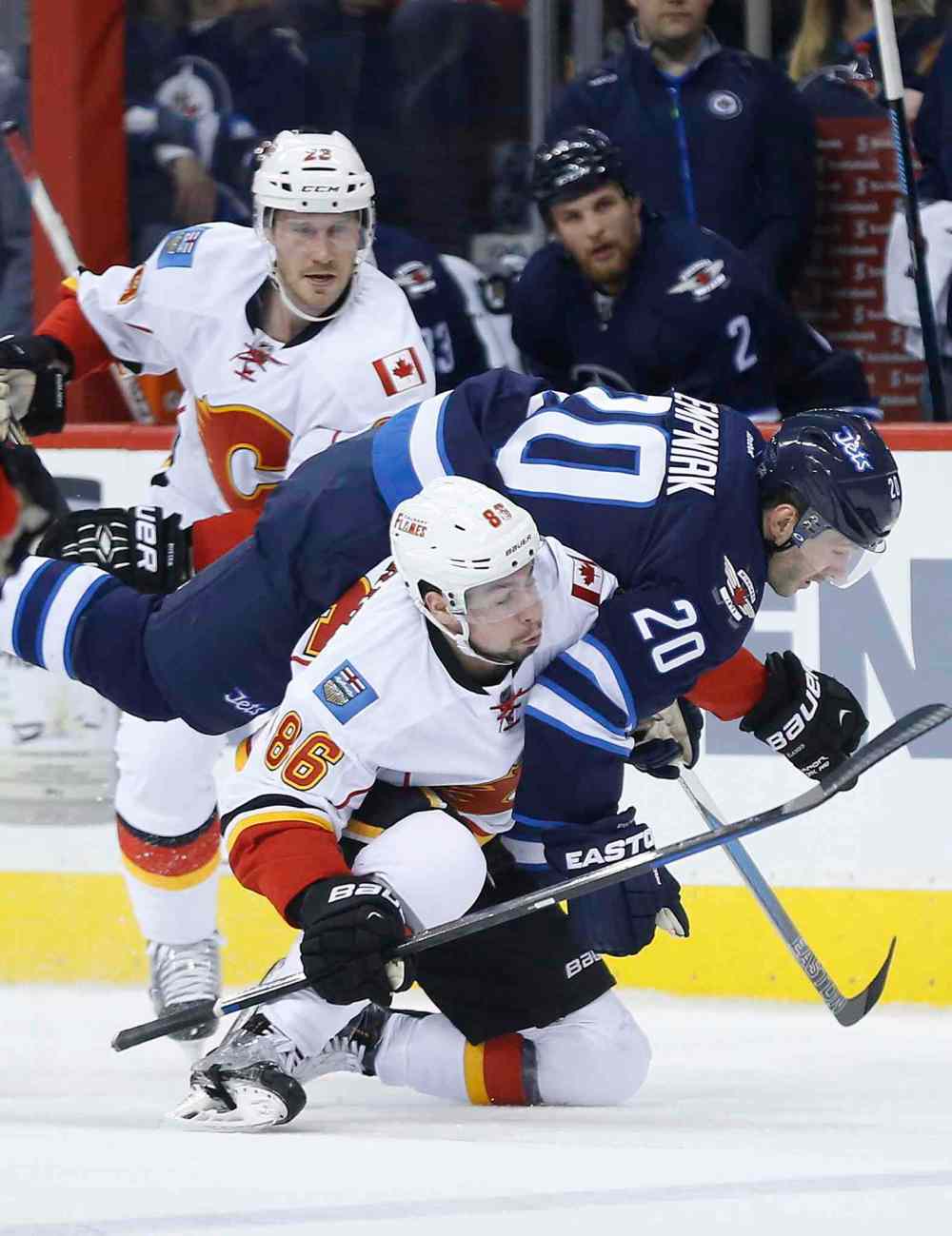 CP
Calgary Flames' Josh Jooris (86) hauls down Winnipeg Jets' Lee Stempniak (20) for the penalty as Flames' Corey Potter (28) looks on during second period NHL action on Saturday.