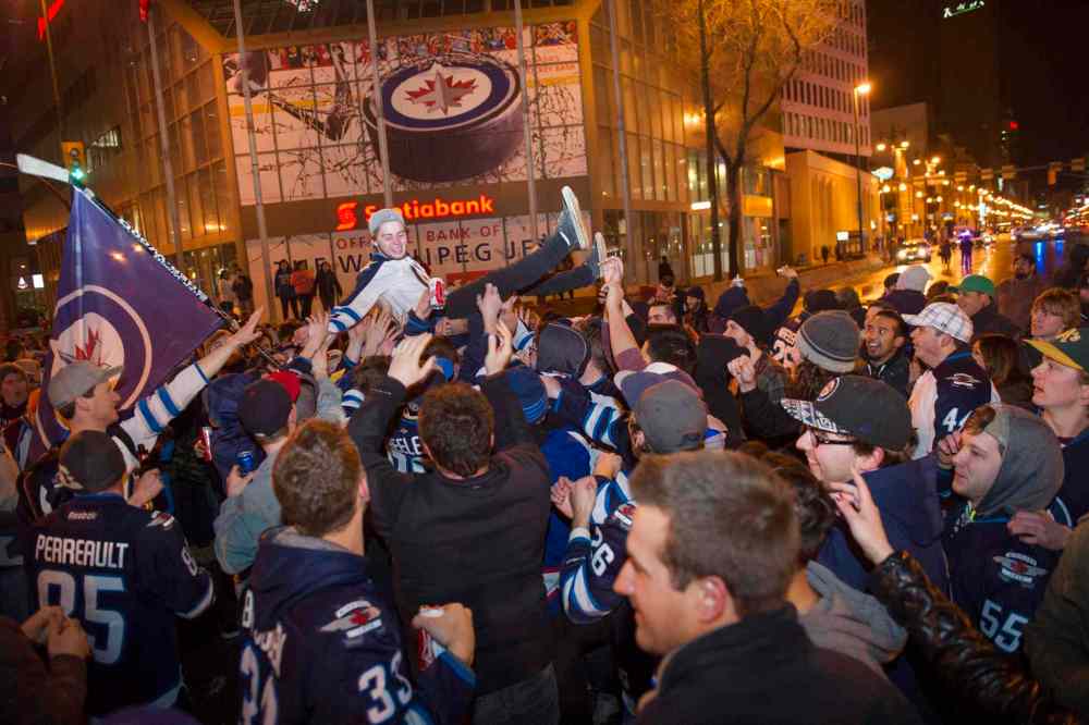 DAVID LIPNOWSKI / THE CANADIAN PRESS
Winnipeg Jets fans gather at the intersection of Portage Avenue and Main Street in Winnipeg Thursday to celebrate the Winnipeg Jets clinching a NHL playoff spot.