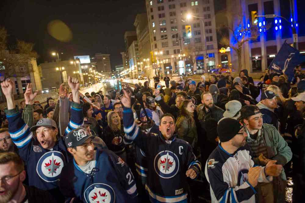 DAVID LIPNOWSKI / THE CANADIAN PRESS
Winnipeg Jets fans gather at the intersection of Portage Avenue and Main Street in Winnipeg Thursday to celebrate the Winnipeg Jets clinching a NHL playoff spot.