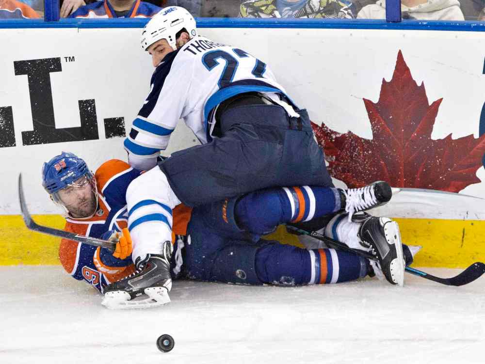 Jason Franson / The Canadian Press
Winnipeg Jets' Eric Tangradi (27) checks Edmonton Oilers' Sam Gagner (89) during the second period on Monday.