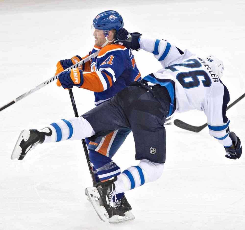 Jason Franson / The Canadian Press
Winnipeg Jets' Blake Wheeler (26) is hit by Edmonton Oilers' Andrew Ference (21) during the second period Monday, before the Oilers trounced the Jets 6-2.