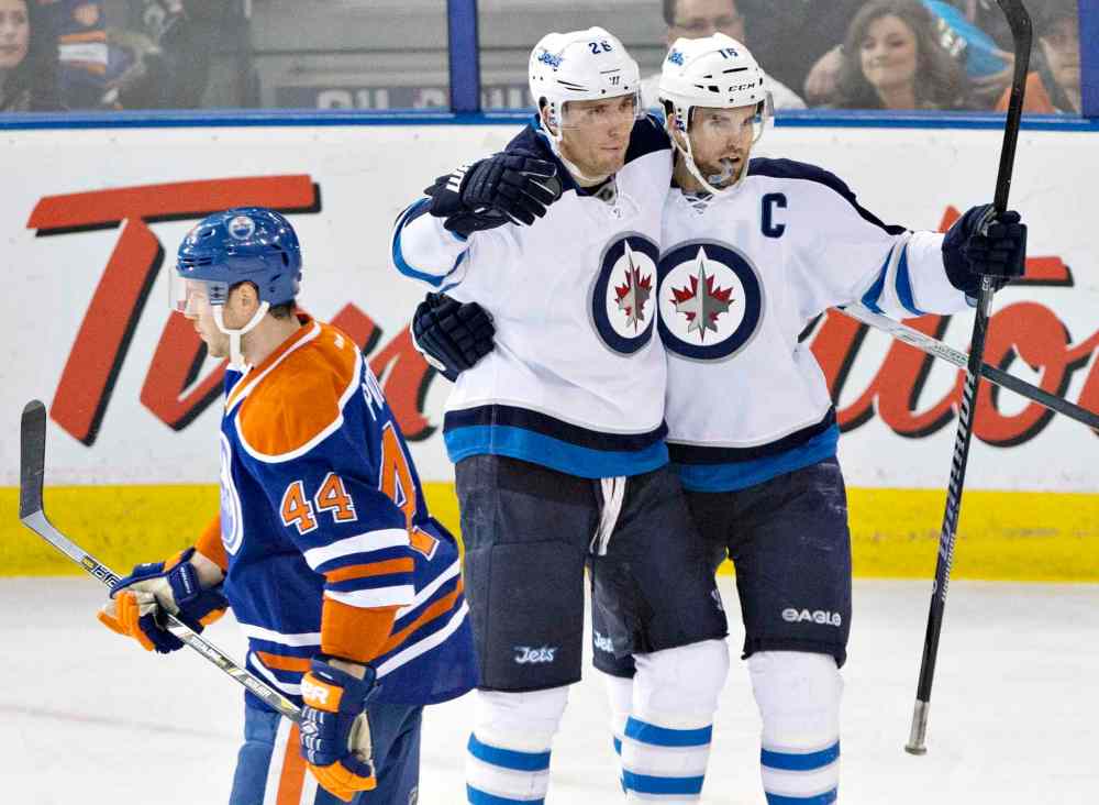 Jason Franson / The Canadian Press
Winnipeg Jets' Blake Wheeler (26) and Andrew Ladd (16) celebrate a goal as Edmonton Oilers' Corey Potter (44) skates past during the second period Monday.