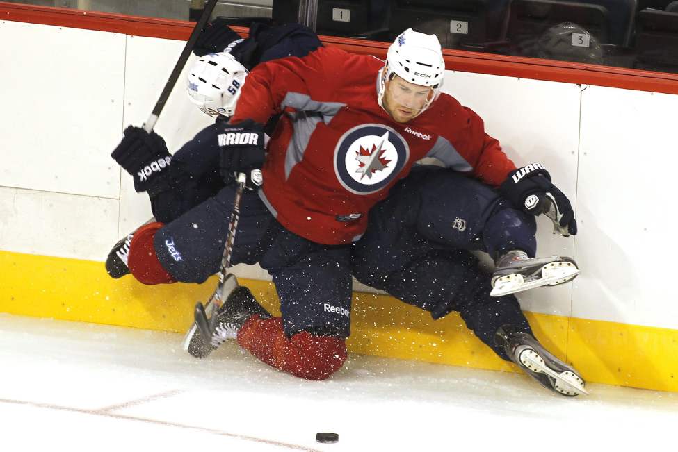John Woods / The Canadian Press
Brett Festerling (53) takes out Eric O'Dell (58) during a scrimmage Sunday.