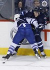 JOHN WOODS / The Canadian Press
Toronto Maple Leafs' Morgan Rielly (44) pins Winnipeg Jets' Mark Scheifele (55) against the boards during the first period in Winnipeg Saturday.