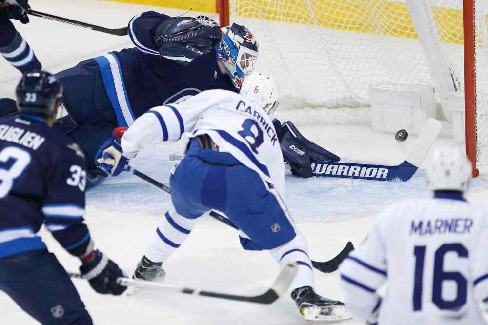 JOHN WOODS / THE CANADIAN PRESS
Toronto Maple Leafs' Connor Carrick (8) scores on Winnipeg Jets goaltender Michael Hutchinson (34) during first period NHL action in Winnipeg on Wednesday, October 19, 2016.