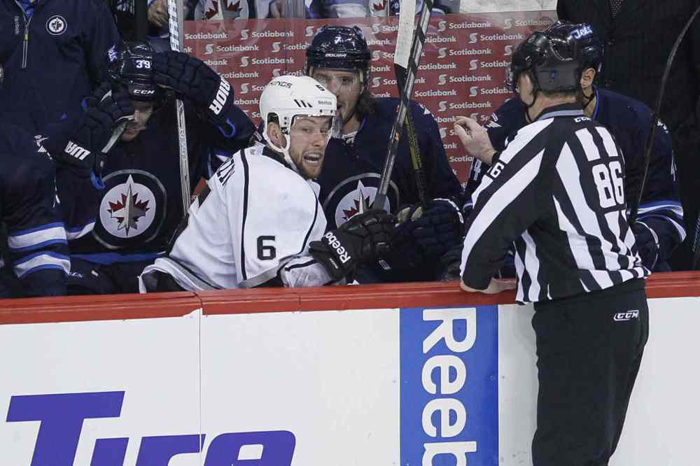 John Woods / The Canadian Press
Los Angeles Kings' Jake Muzzin (6) climbs out of the Winnipeg Jets' bench after being dumped over the boards.