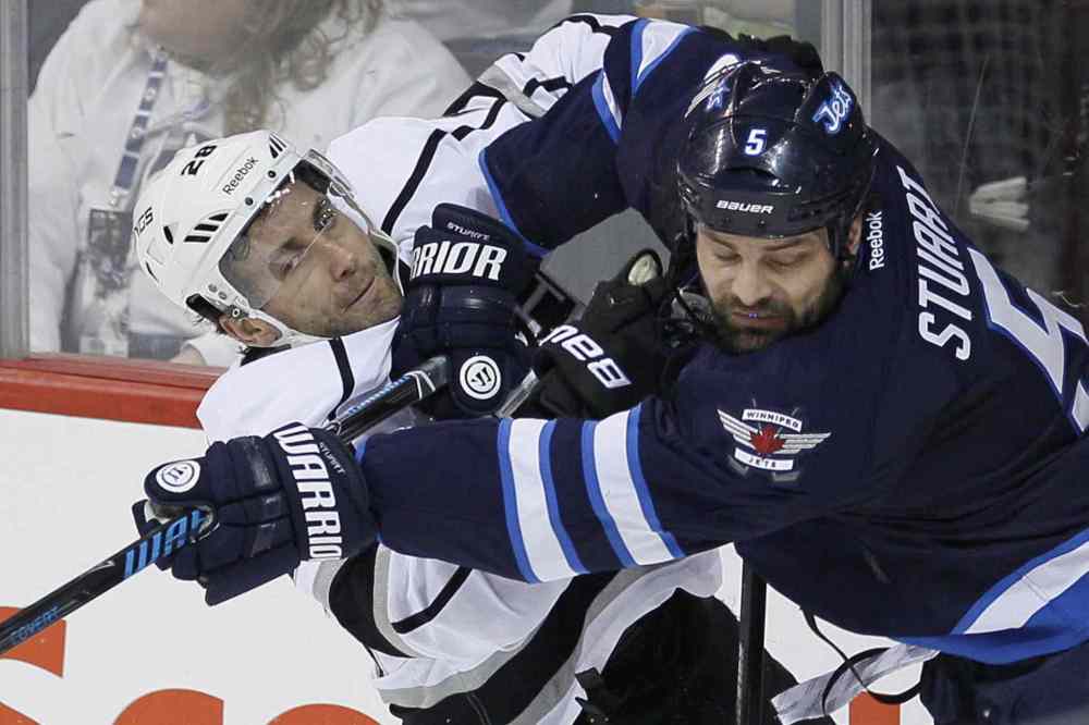 John Woods / The Canadian Press
Winnipeg Jets' Mark Stuart (5) checks Los Angeles Kings' Jarret Stoll (28) during the first period in Winnipeg on Thursday.