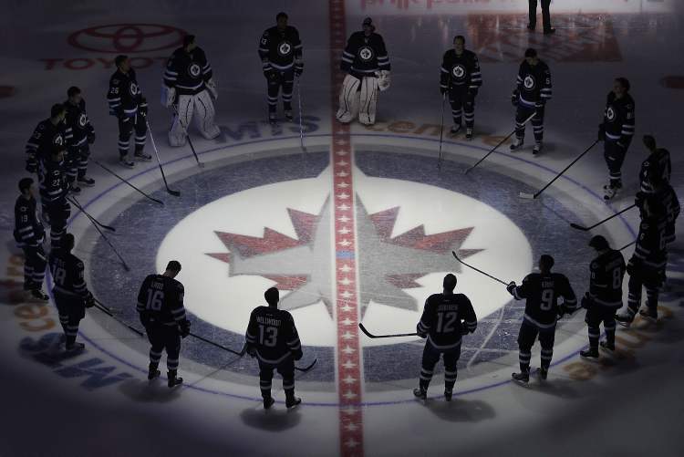 john woods / the canadian press
The Winnipeg Jets gather at centre ice prior to their game with the Ottawa Senators in Winnipeg Saturday