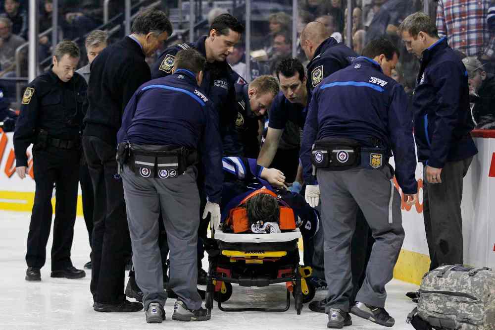 JOHN WOODS / THE CANADIAN PRESS
Winnipeg Jets' Jacob Trouba (8) is attended to by paramedics after crashing head first into the boards during second period NHL action against the St. Louis Blues in Winnipeg on Friday, October 18, 2013. THE CANADIAN PRESS/John Woods