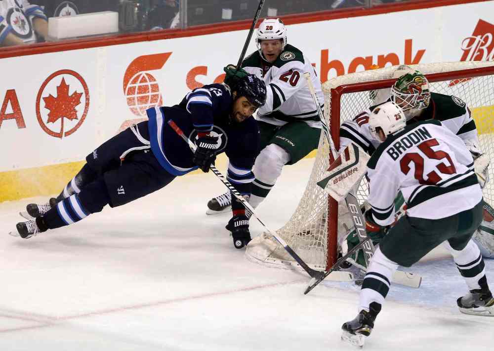 Trevor Hagan / The Canadian Press
Winnipeg Jets' Dustin Byfuglien (33) loses his footing as he tries a wraparound on Minnesota Wild's goaltender Devan Dubnyk (40) with Ryan Suter (20) trailing and Jonas Brodin (25) guarding the net during first period NHL hockey action in Winnipeg Sunday.